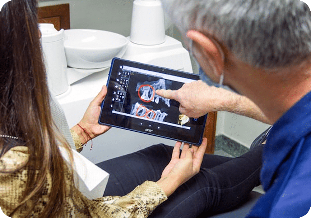 Dentist reviewing an implant treatment plan on a tablet with a patient
